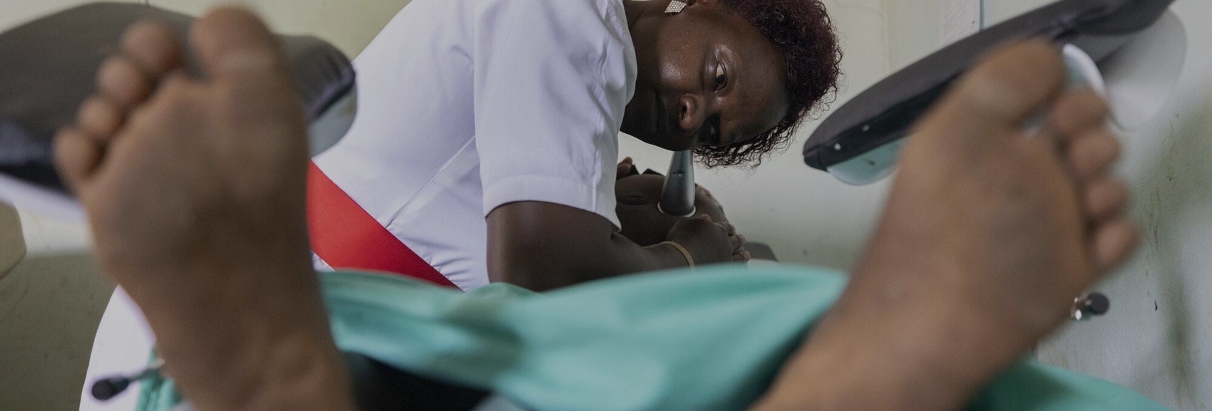 A healthcare worker performing an ultrasound scan on a patient, emphasizing access to essential medical care and prenatal health support.