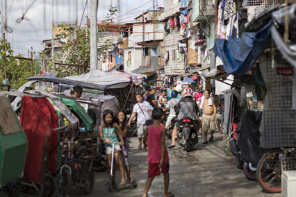 Kids and adults walk on the road outside in Philippines.