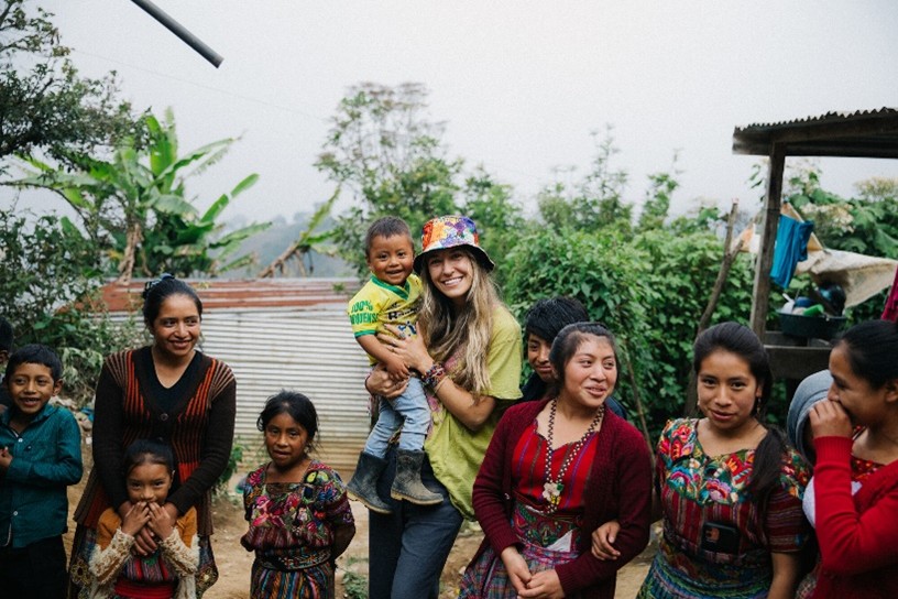 Pop singer Lauren Daigle stands with sponsored children.