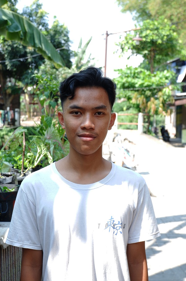 Young man in Indonesia looks at camera pensively.