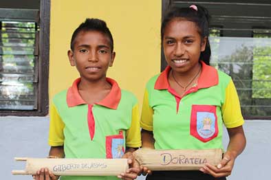  boy and girl standing outdoors holding wood wooden piggybank with name 