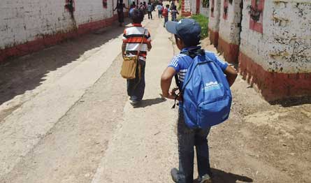  group walking down street carrying backpacks 