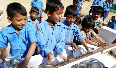  boys standing outdoors cleaning plates 